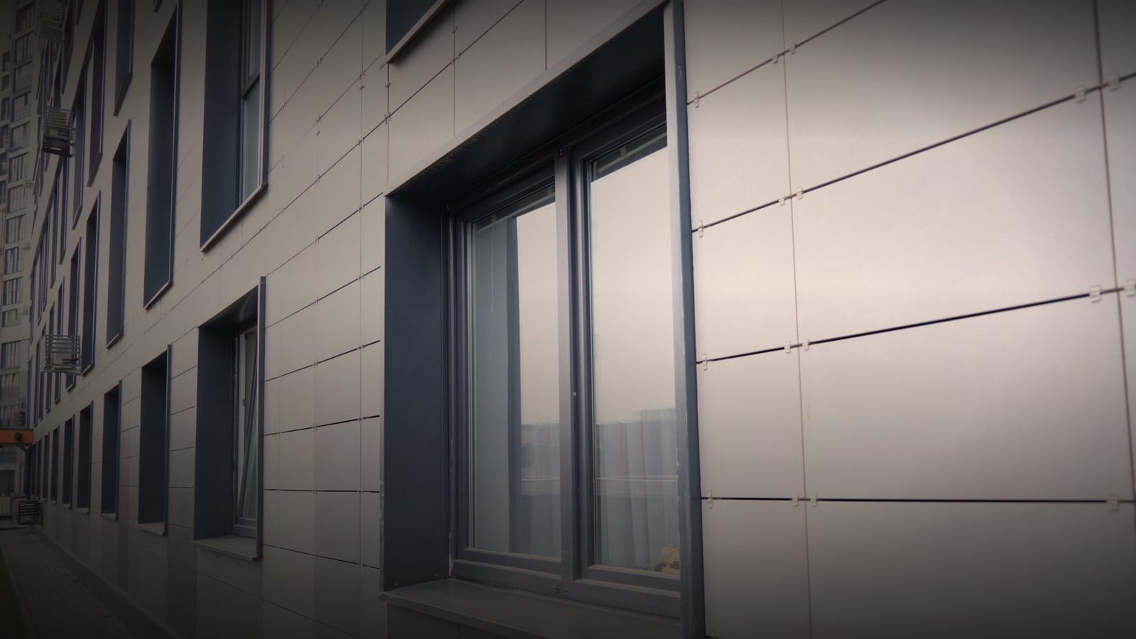 Finished panel cladding and window detailing on a completed modern facade